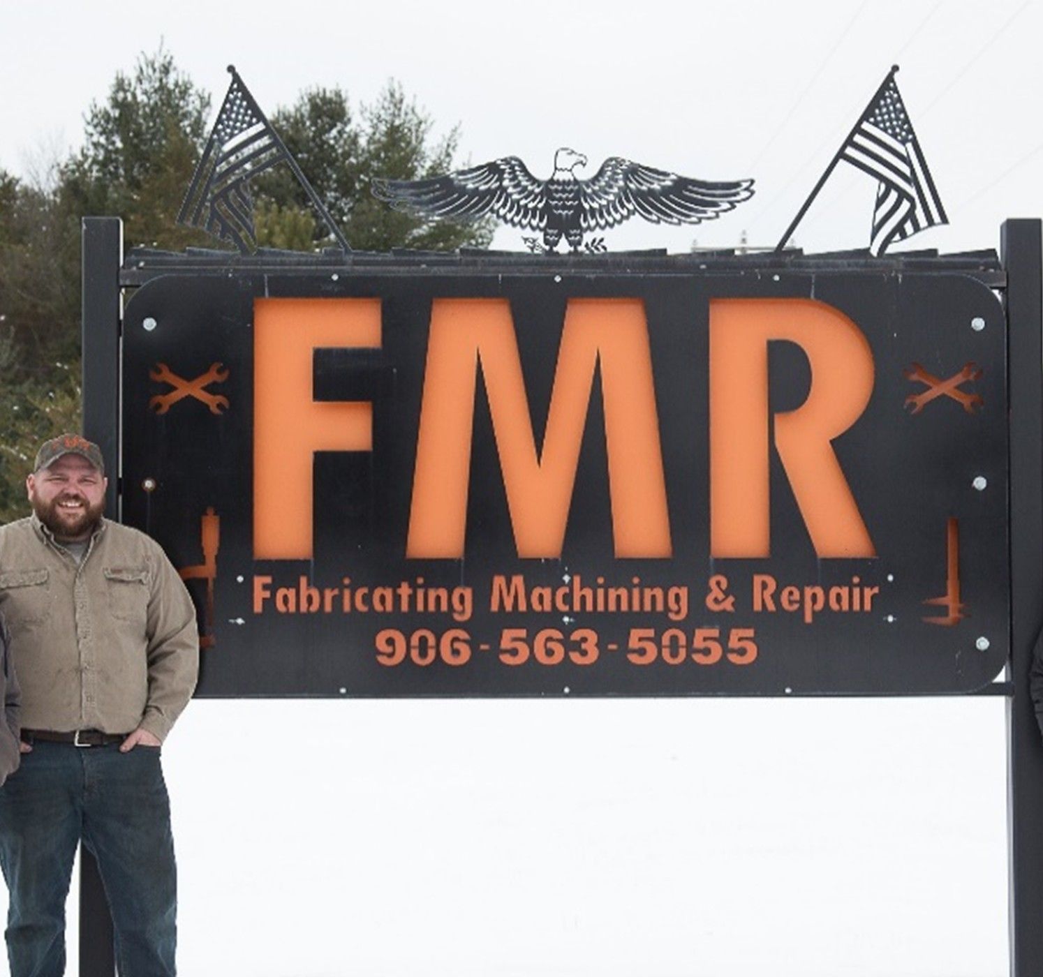 Owner and sign in front of building